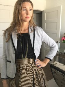gray blazer, black top, and striped skirt