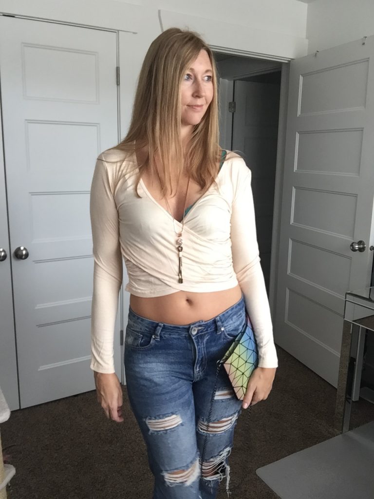Woman in beige croptop and distressed denim jeans